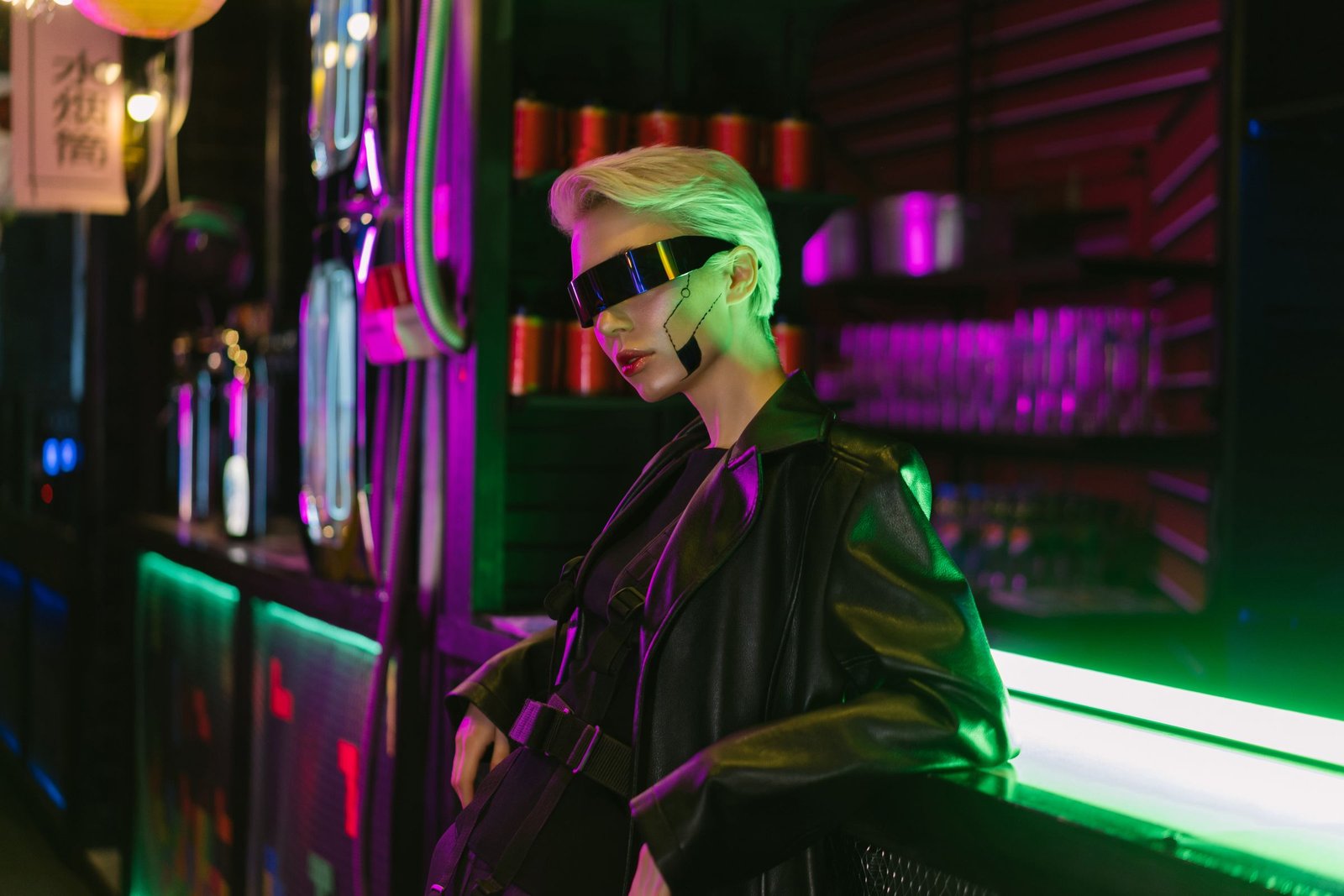 Mulher em jaqueta de couro e óculos futuristas, com marca facial tipo circuito sob neon